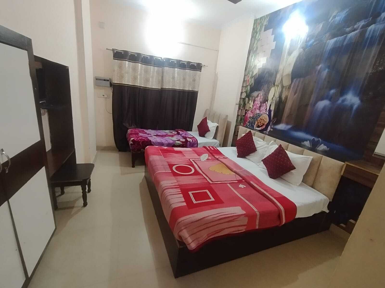 Una habitación de hotel con dos camas, un armario, un escritorio y un mural grande en la pared.