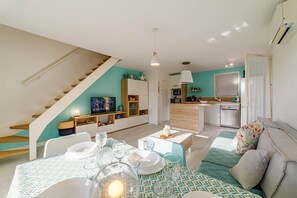 Un appartement moderne comprenant un coin repas, une cuisine et un espace de vie.