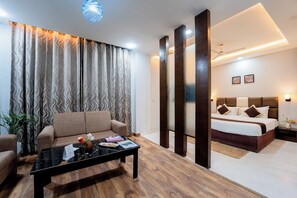 Una camera d'hotel moderna con un divano, un tavolino, un letto e un comodino.