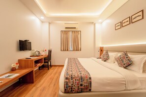A hotel room with a bed, a desk, a chair, a television, and a window with curtains. - HHW Hotel- Agra (Agra)