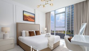 Een moderne hotelkamer met een groot bed, een bureau en uitzicht op de stad.