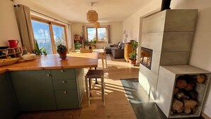 A modern kitchen with wooden countertops, a dining area, and a fireplace.