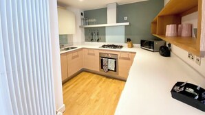 Una cocina moderna con una isla central, horno empotrado y microondas.
