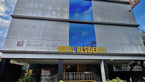 Ein Gebäude mit einer Fassade, auf der die Schilder "ROYAL RESIDENCY" und "Impeks" zu sehen sind.
