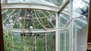 A conservatory with a table, chairs, and potted plants. - Circus wagon star tent with sauna. Very spacious with pavilion. (Windeck)