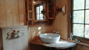 A wooden cabin bathroom with a wooden toilet, a large sink, and a mirror above the sink. - Circus wagon star tent with sauna. Very spacious with pavilion. (Windeck)