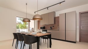 A modern kitchen with a dining area. - AdeLis Residence (Piran)