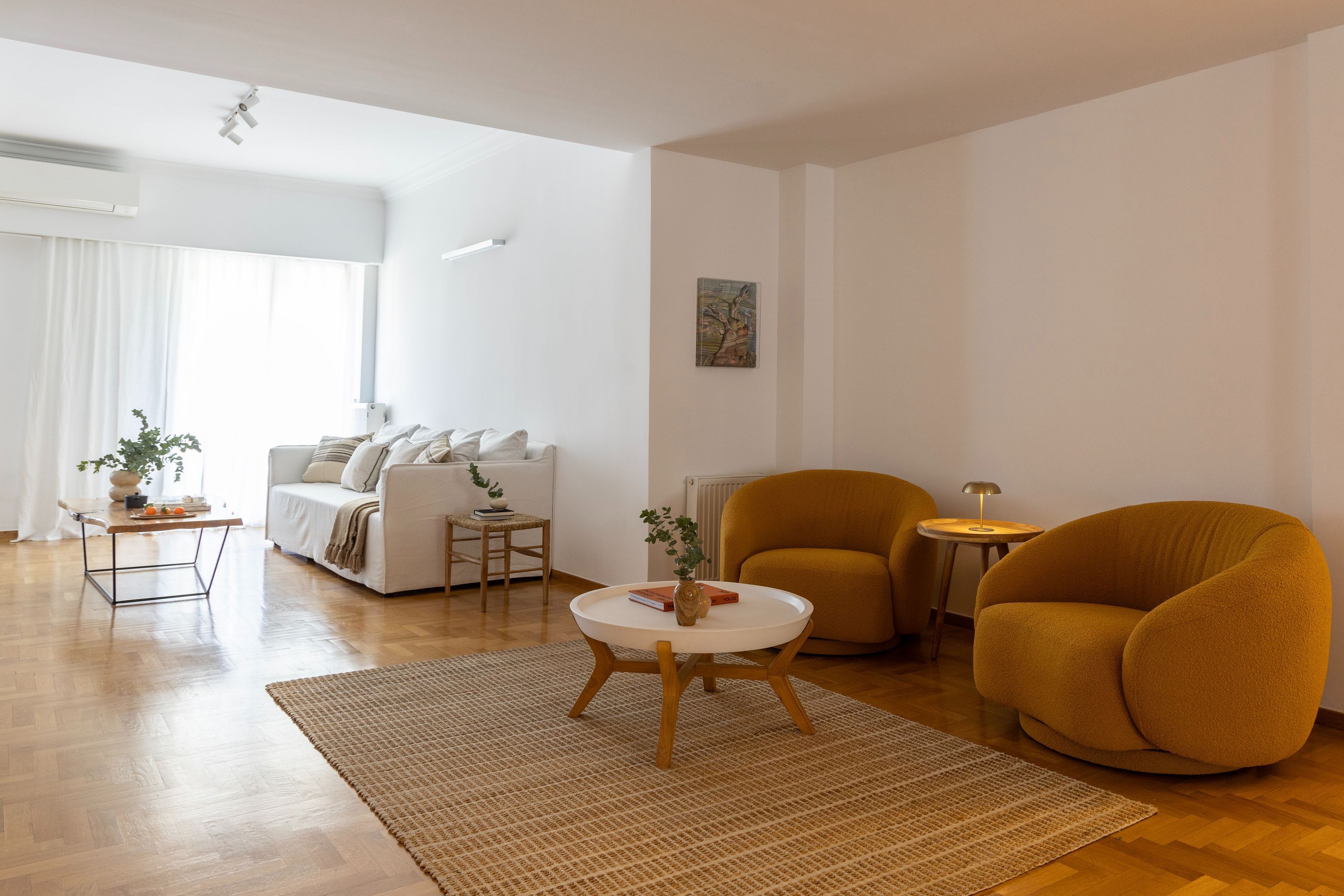 A modern living room with a sofa, armchairs, a coffee table, and a small side table.