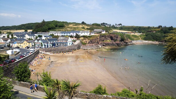 A coastal town with a sandy beach, stone walls, and houses with distinct architectural styles. - Dunmore Villas Holiday Home No 1 (Dunmore East)