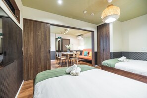 Une chambre d’hôtel avec deux lits, un coin repas et une salle de bain.