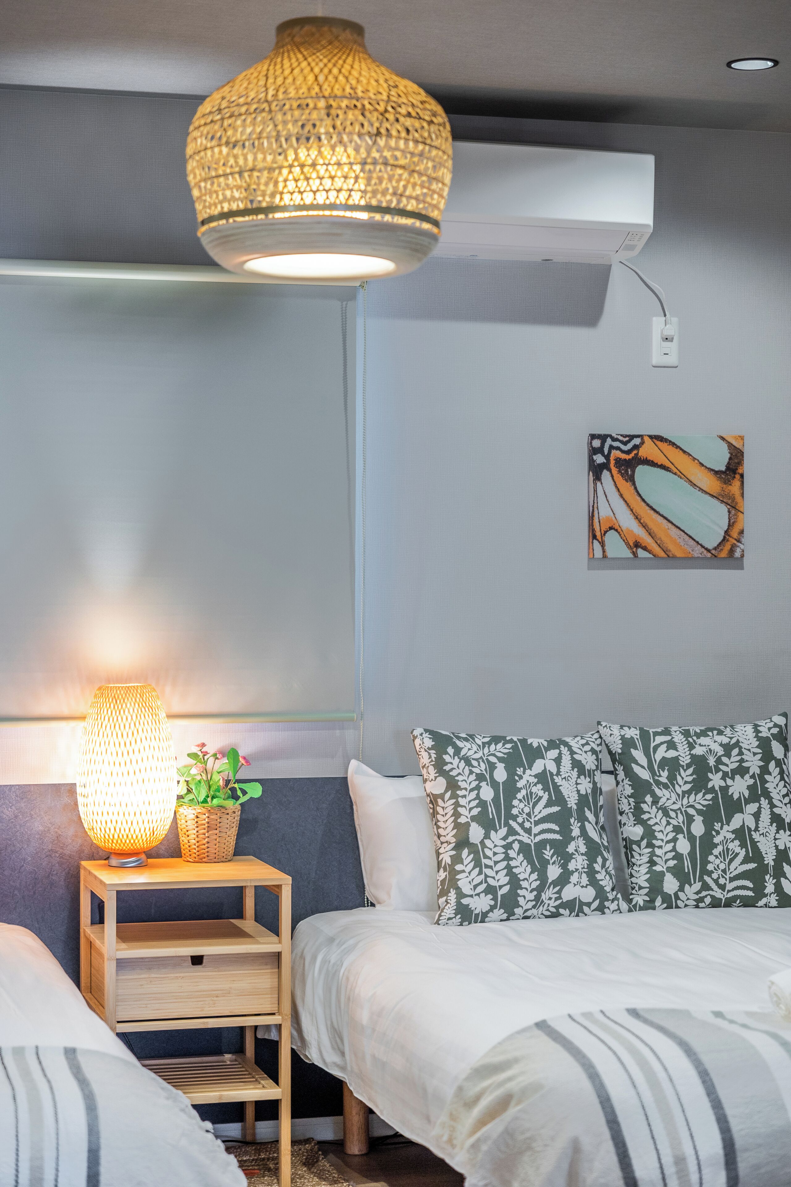 A bedroom with a bed, bedside table, lamp, and wall art.