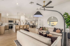 Una sala moderna con un sofá, un comedor y una cocina.