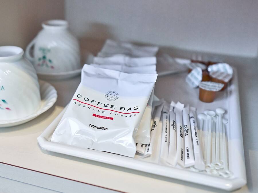 A coffee station with a coffee bag, tea bags, and teapots.