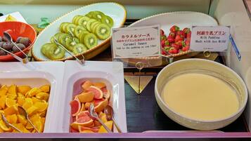 A buffet with various food items including sliced kiwi, strawberries, and citrus fruits.
