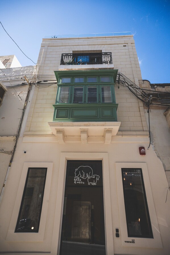 A building with a green window and a sign that reads "The Bear & The Ween."