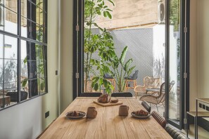A dining area with a wooden table, chairs, and a view of the outdoor patio.