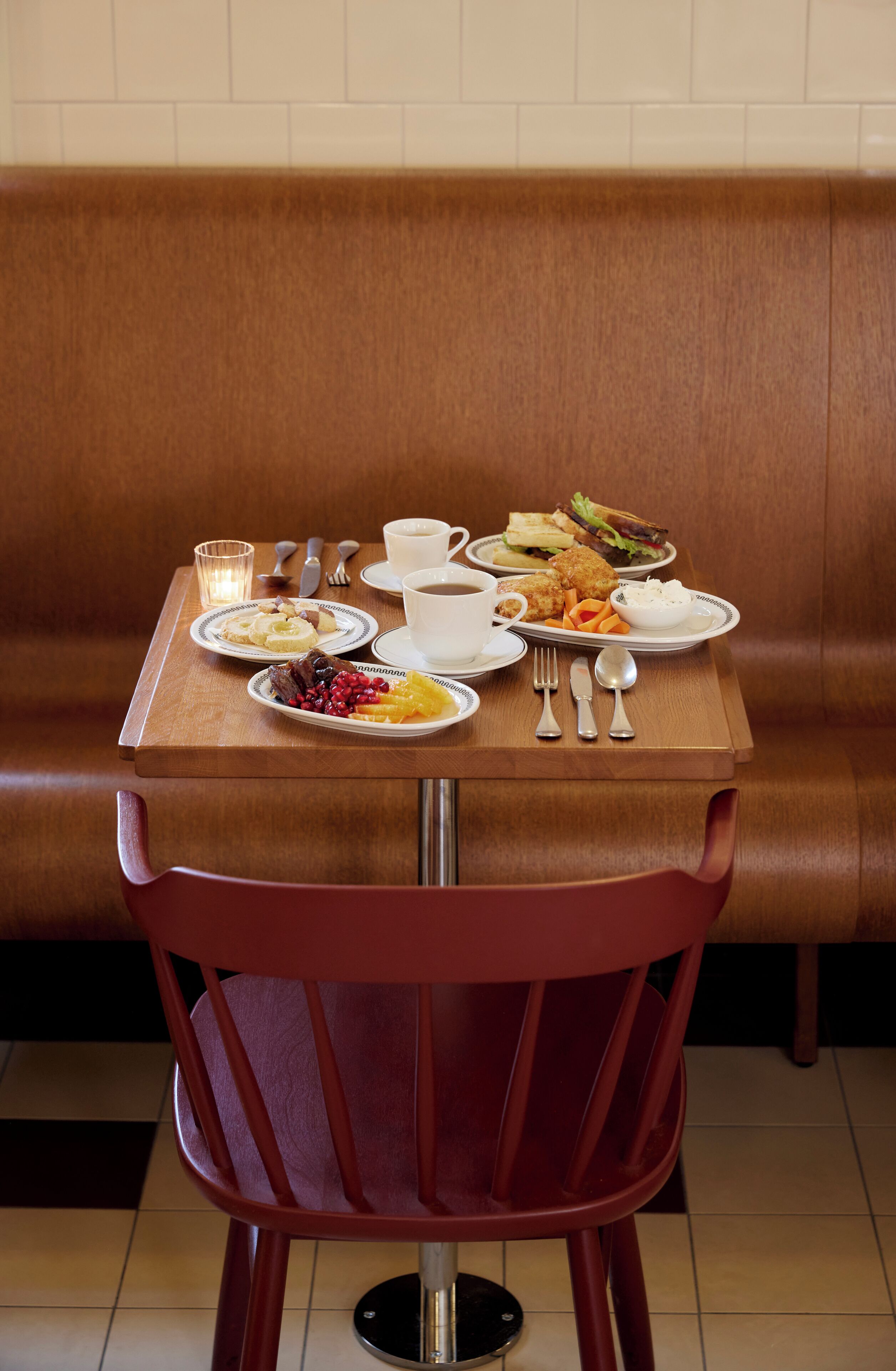 Une table à manger avec des assiettes remplies de nourriture, des couverts et une tasse de café.
