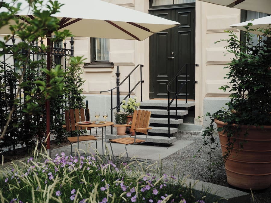 A patio with outdoor seating, a staircase, and potted plants.