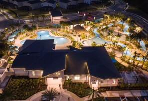 Ein Resort mit Schwimmbad, Liegebereichen und einem gut beleuchteten Gebäude.