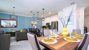 A modern dining area with a wooden table set for six, surrounded by chairs. - Storey Lake Resort, Private Pool, Near Famous Attractions!! (Kissimmee)