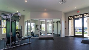 A gym with exercise equipment, glass doors, and a view of the outside. - Storey Lake Resort, Private Pool, Near Famous Attractions!! (Kissimmee)