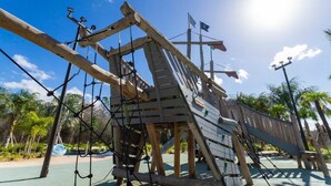 A wooden play structure with ropes and a slide, surrounded by palm trees and a clear sky. - Storey Lake Resort, Private Pool, Near Famous Attractions!! (Kissimmee)