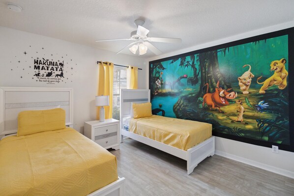 A bedroom with two beds, a ceiling fan, and a large jungle-themed wall mural. - Great Community, Amazing Private Pool, Near Disney! (Davenport)