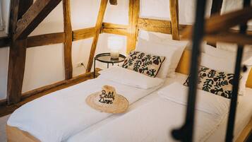 A cozy room with a bed, a nightstand, and a lamp.
