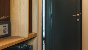 Uma cozinha compacta com micro-ondas embutido, um refrigerador pequeno e prateleiras de madeira.