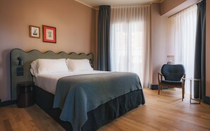 A neatly arranged bedroom with a bed, a chair, and two framed pictures on the wall. - c-hotels Alamanni21 (Florence)