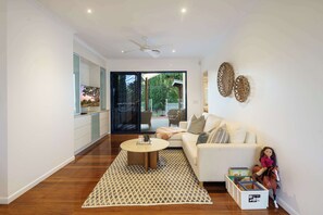 A modern living room with a sofa, coffee table, and a doll on a horse.