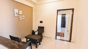 A room with a dining table and chairs, a small sofa, and a door leading to another room. - House of Brothers  (Arambol)
