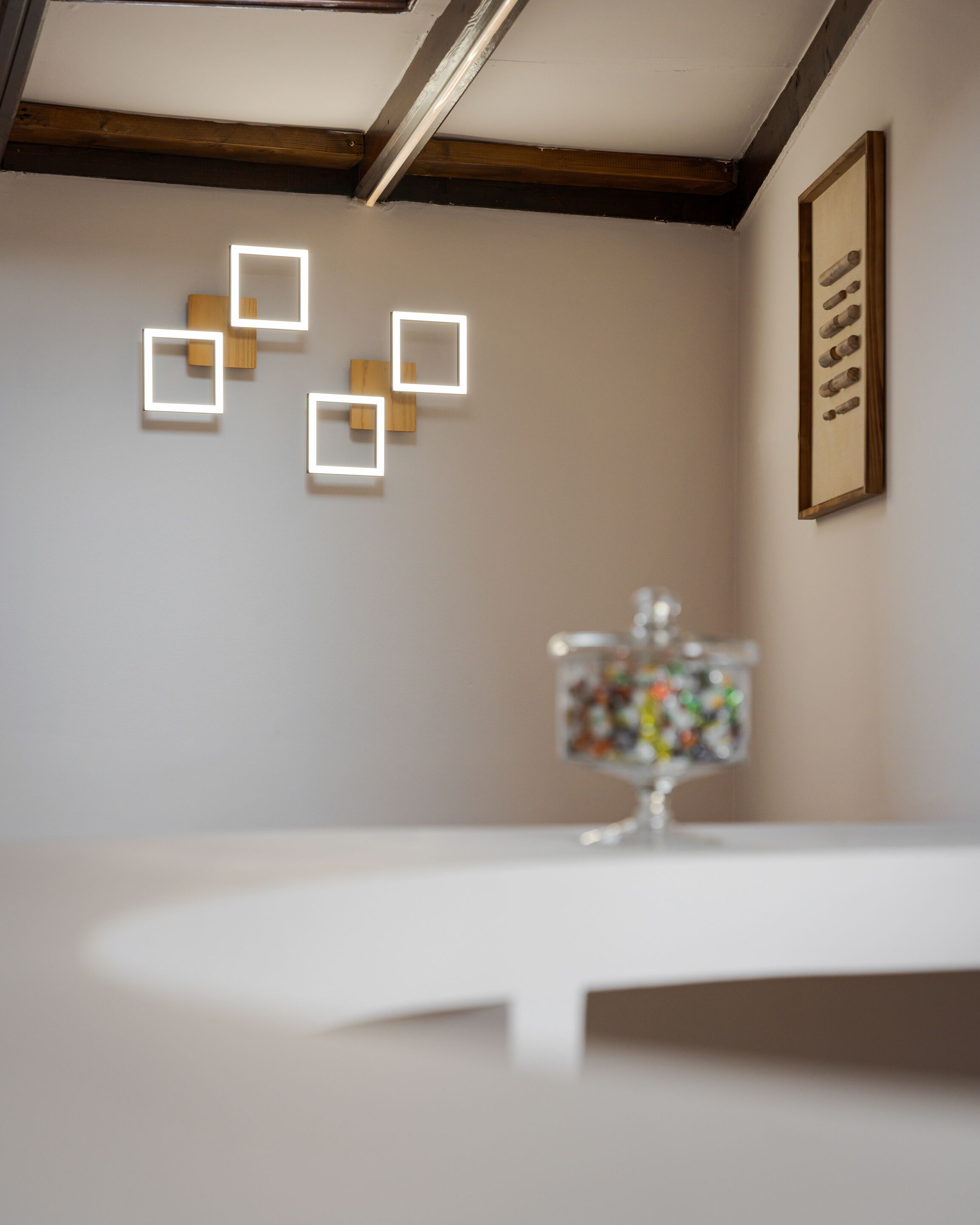 A room with a white table, a wall-mounted light fixture, and a framed picture.
