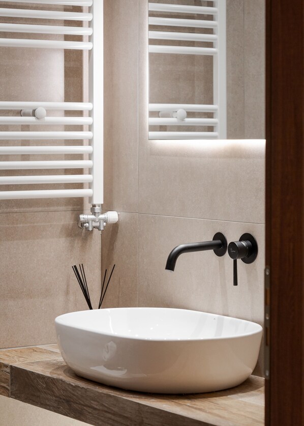 A bathroom with a white vessel sink, a black faucet, and a mirror reflecting a towel rack. - Mons Arachova (Distomo-Arachova-Antikyra)