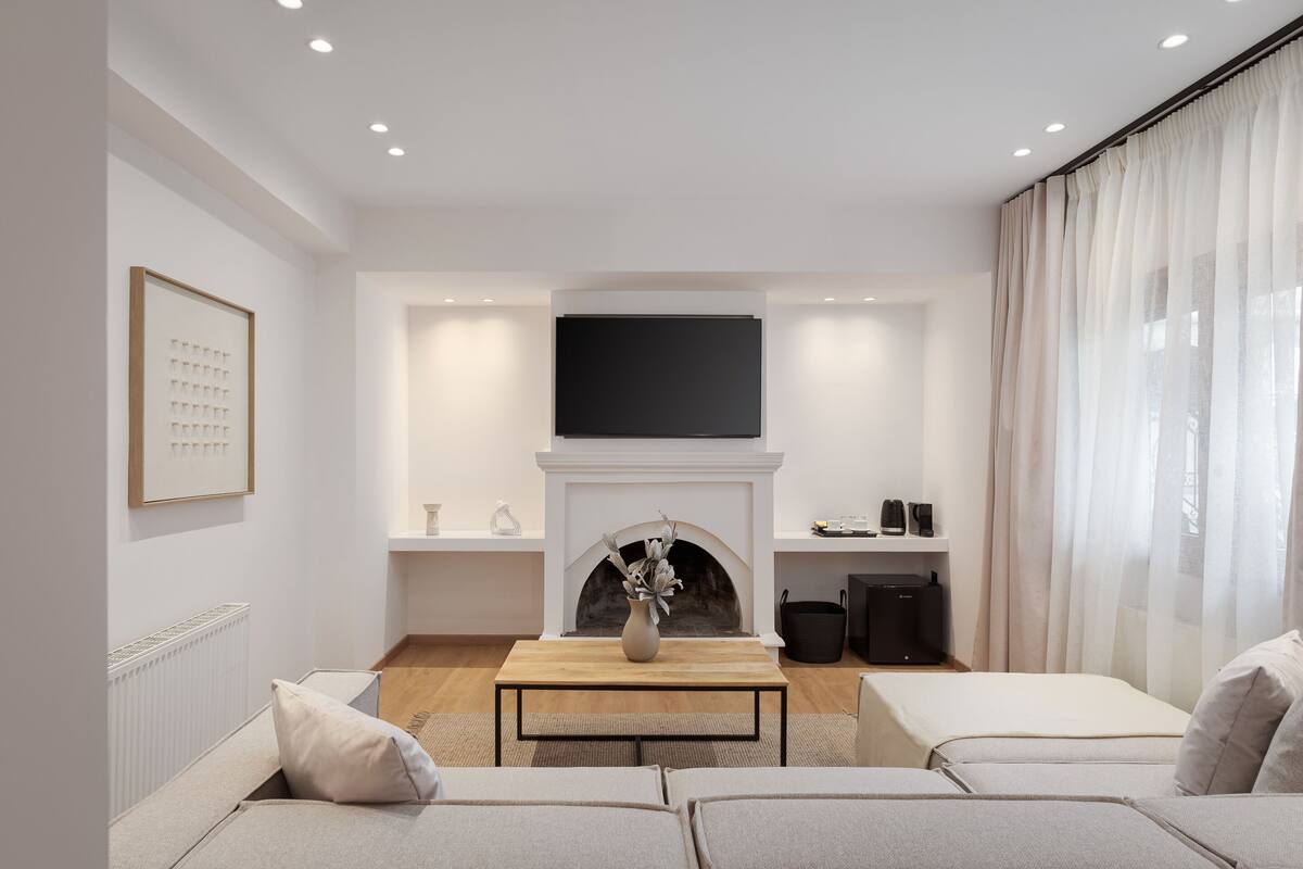 Un salon moderne avec une cheminée, un téléviseur à écran plat et un ensemble de canapés.