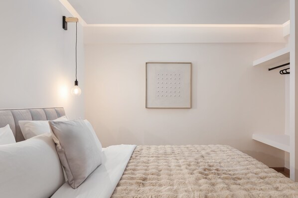 A modern bedroom with a large bed, a wall-mounted light, and a framed picture. - Mons Arachova (Distomo-Arachova-Antikyra)