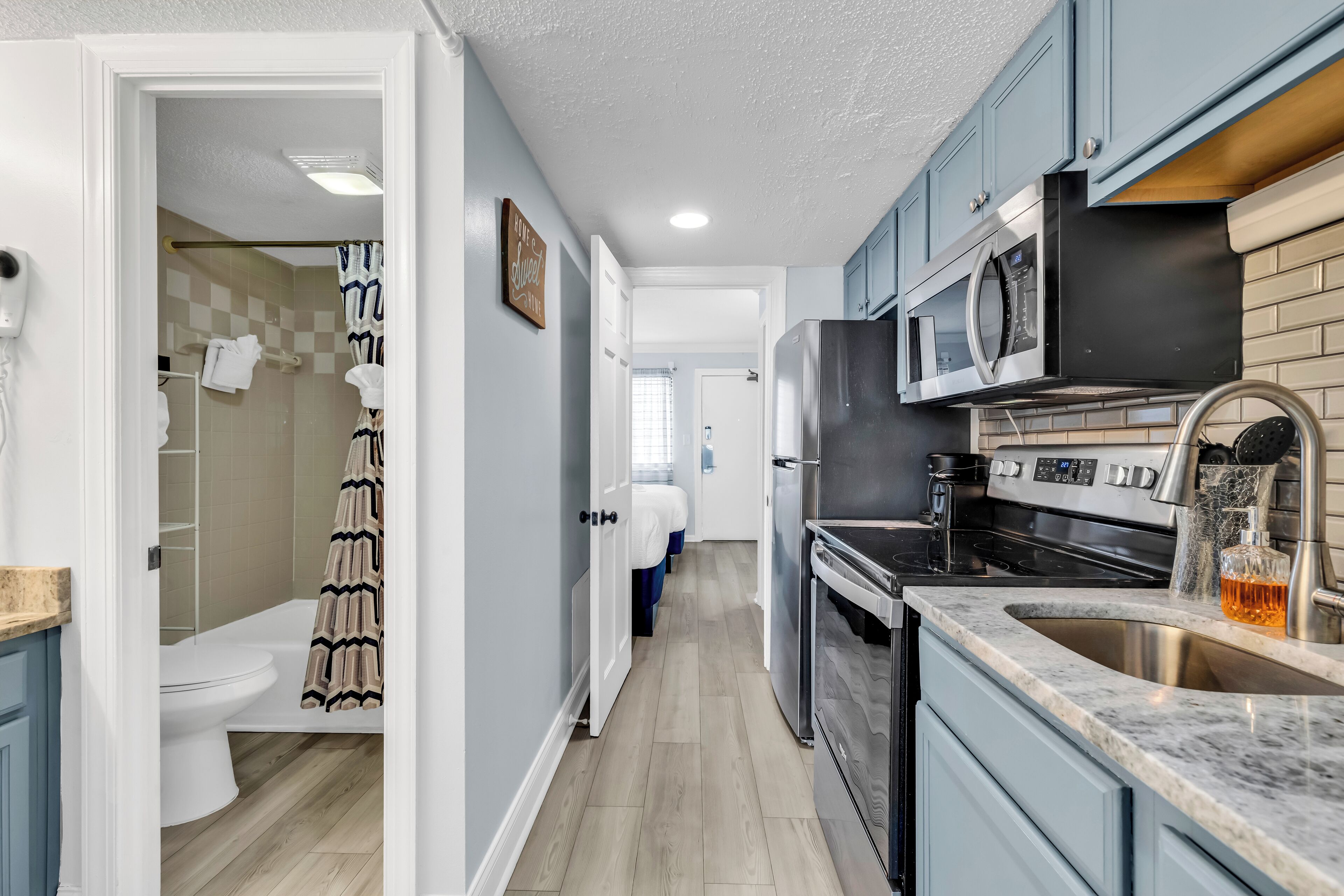 A modern kitchen with a microwave, oven, and sink.