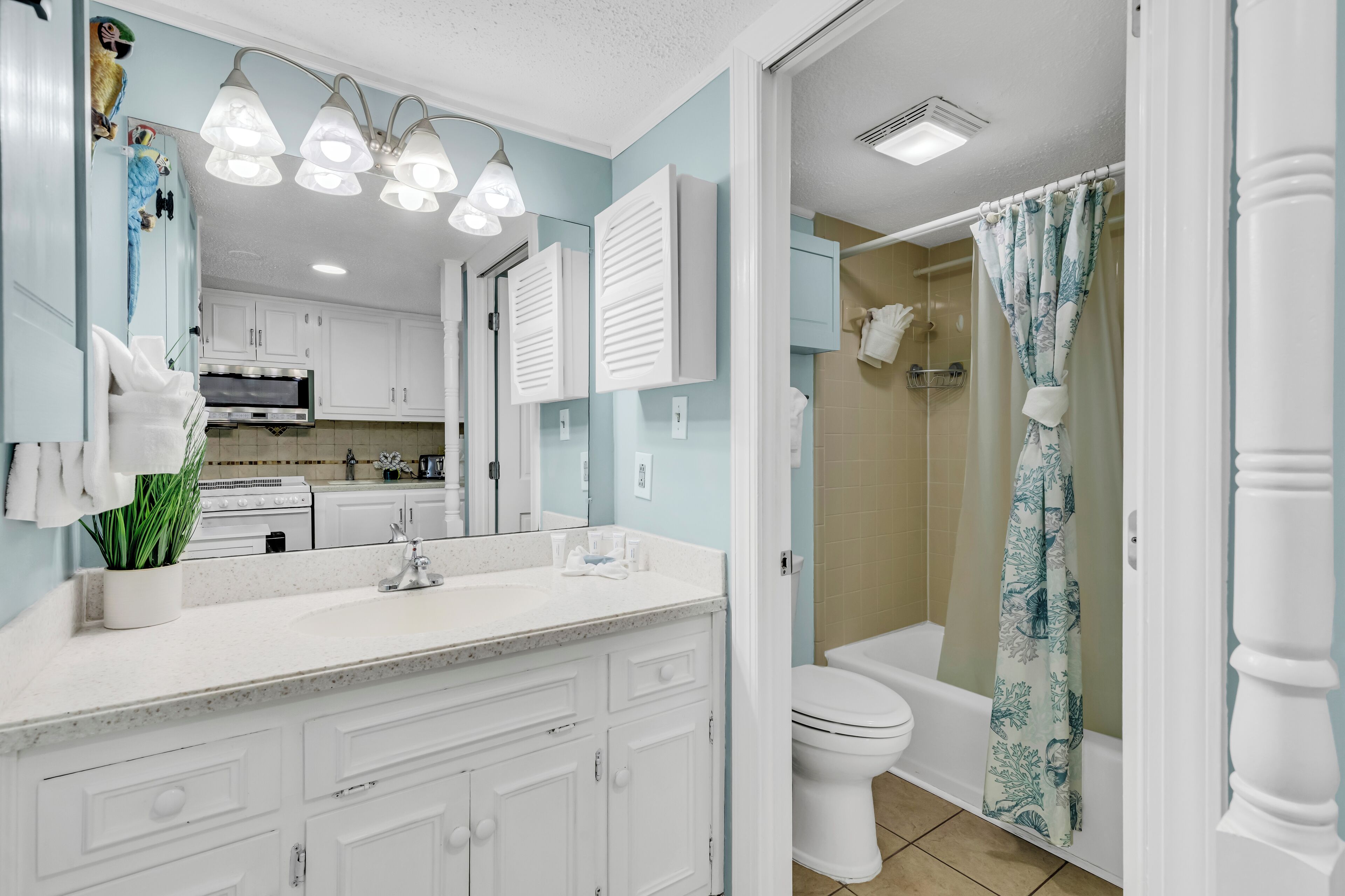 A modern bathroom with a shower curtain, a toilet, and a sink with a mirror.