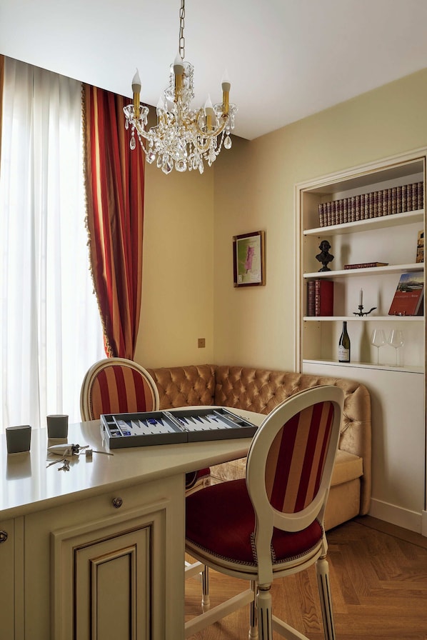 Una habitación con escritorio, silla, estantería y candelabro.