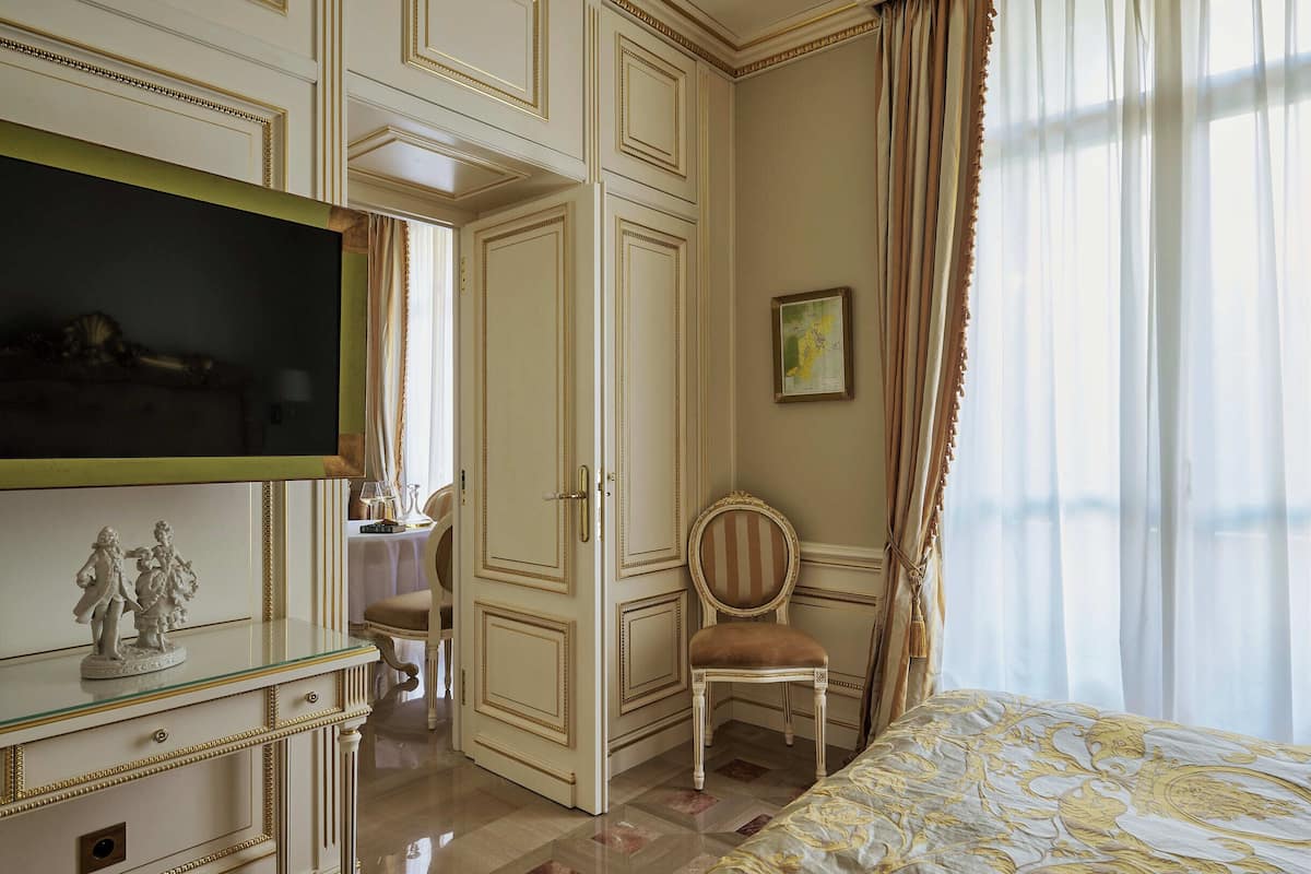 Une chambre avec un lit, une télévision, une chaise et un bureau.