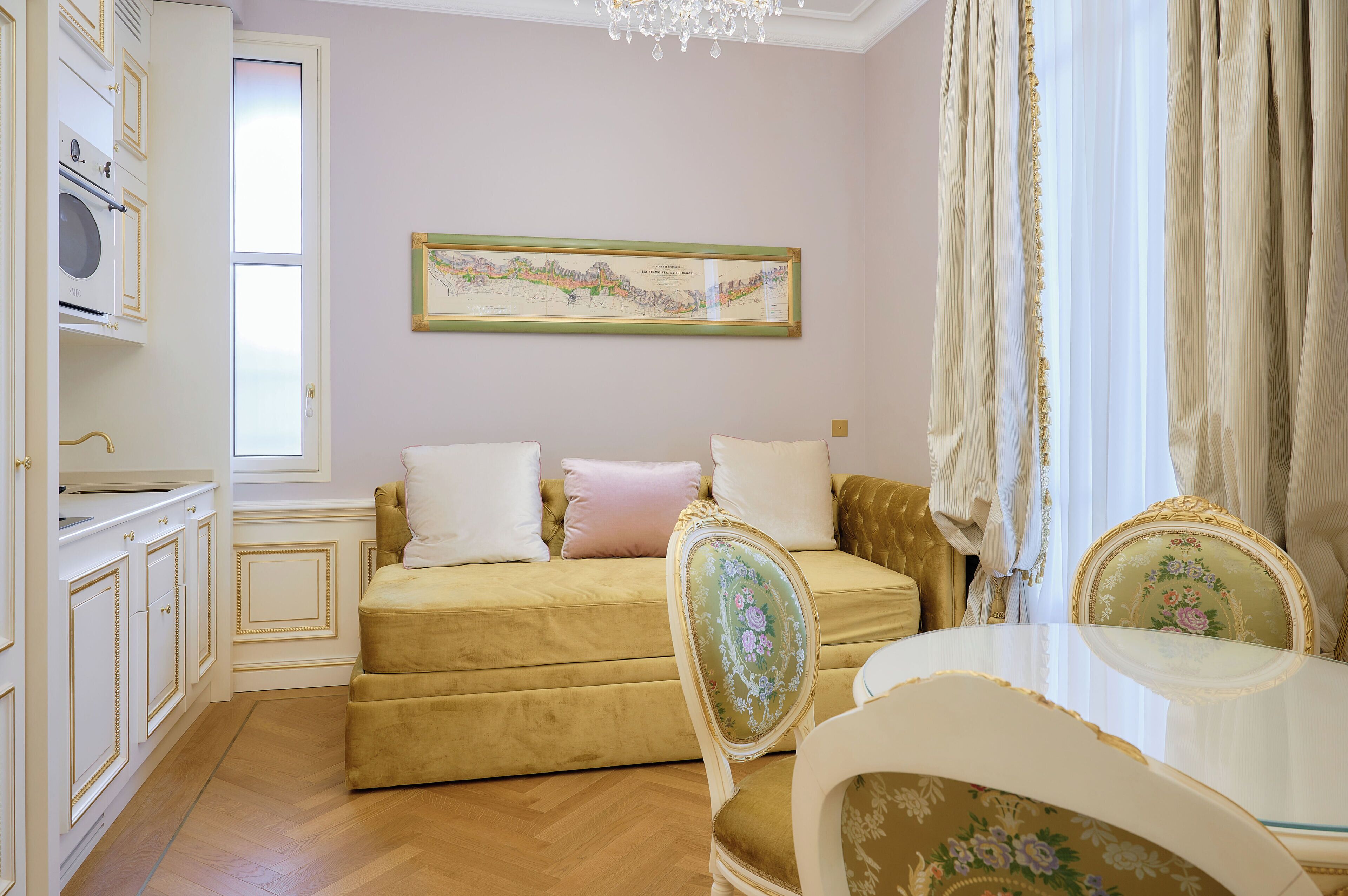 Une pièce avec un canapé beige, une table à manger et un lustre.
