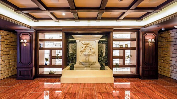 A lobby with a marble fountain, wooden paneling, and stone walls. - Apartment Hotel 11 Namba Motomachi (Osaka)
