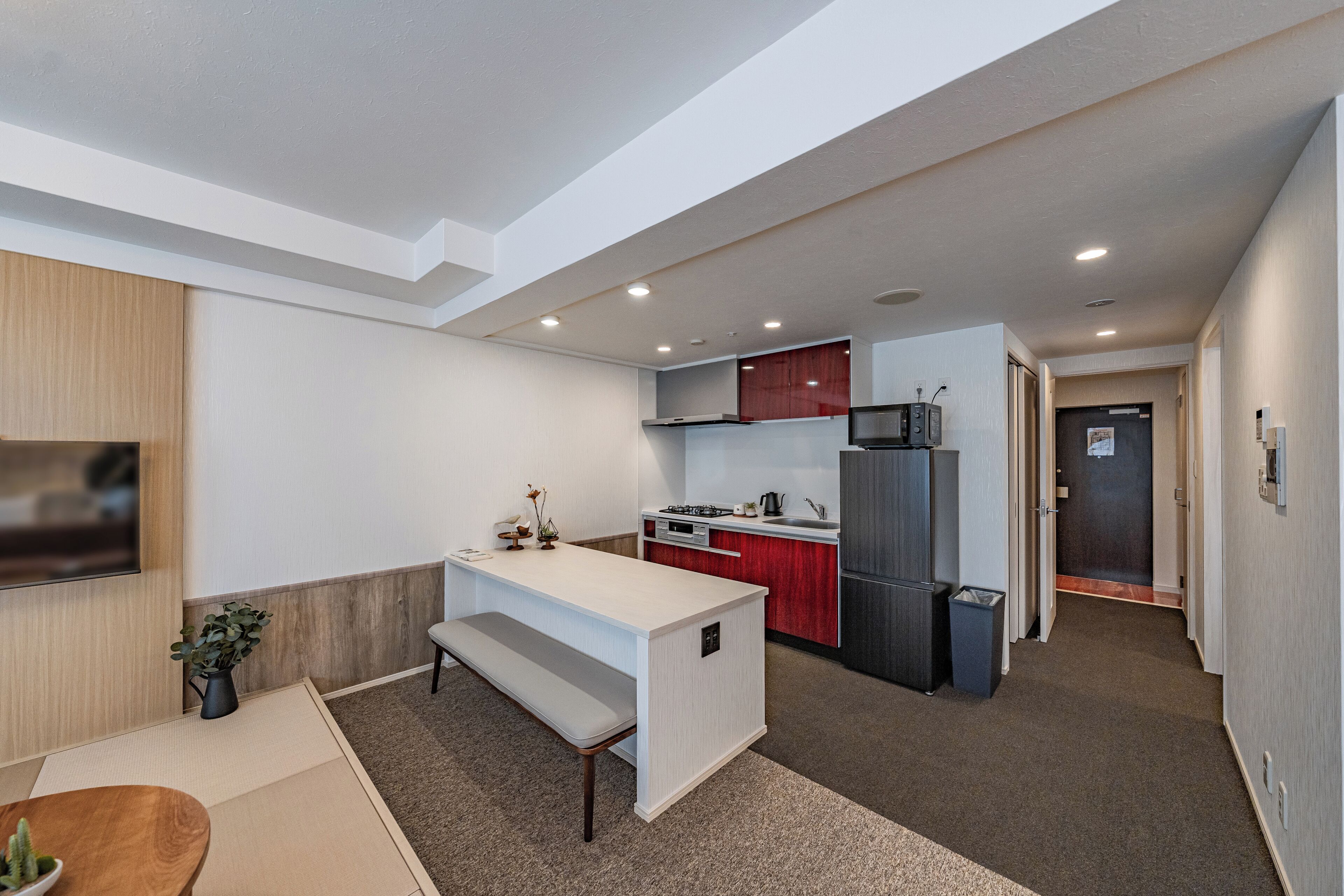 A modern kitchen with a central island, a microwave, and a refrigerator.