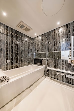Un bagno moderno con una vasca freestanding, uno spazio doccia in vetro e un mobile lavabo con specchio.