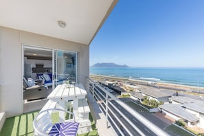 A balcony with a view of the ocean and a distant mountain range. - Blouberg Beauty Sea & Table mountain views (Milnerton)