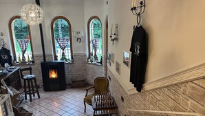 A cozy interior with a fireplace, arched windows, a staircase, and a dining area. - descrizione (Fontana Nuova)
