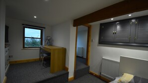 A bedroom with a bed, a desk, and a window. - Cosy bungalow with amazing views  (Filey)