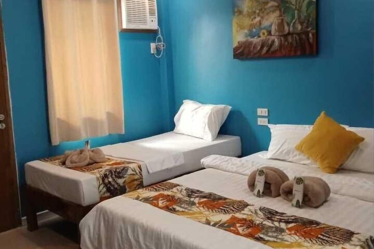 A hotel room with two beds, a painting on the wall, an air conditioning unit, and a window with curtains.