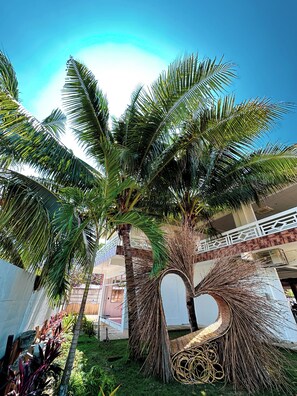 A palm tree in a garden with a heart-shaped structure made of branches. - On Board Lifestyle Panglao Resort (Panglao)