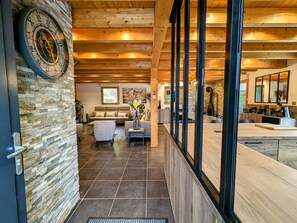 A modern interior with a stone wall, wooden ceiling, and a large clock.